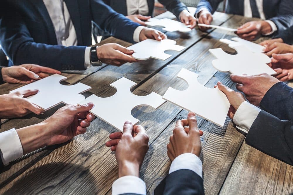 A team fitting puzzle pieces together